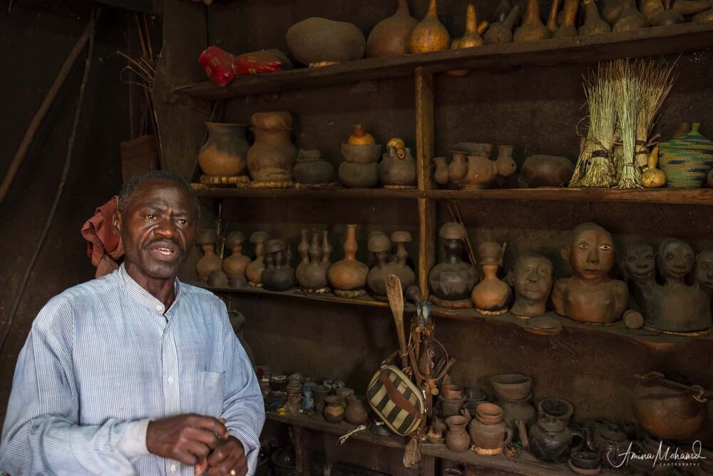 Man selling handmade pottery out of his shed in Rwenzori Mountains @Amina Mohamed Photography